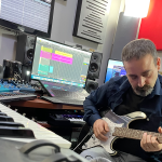 Luigi Sansò in studio di registrazione che suona la chitarra