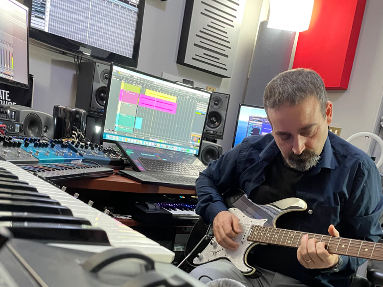 Luigi Sansò in studio di registrazione che suona la chitarra
