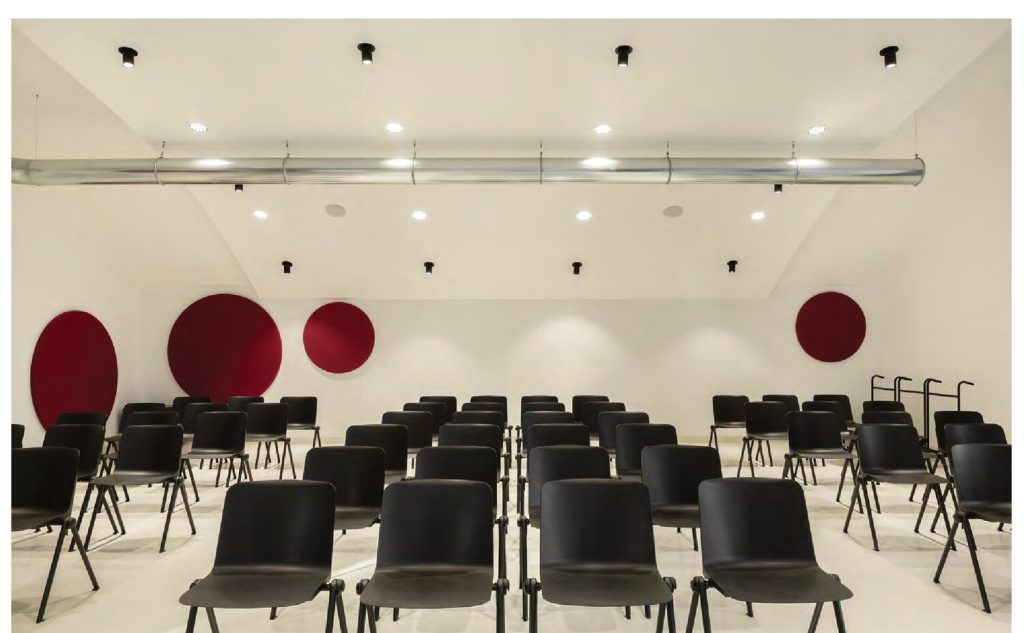 Dischi fonoassorbenti Melodia a parete rossi e teal in auditorium — Biblioteca di Castel Maggiore