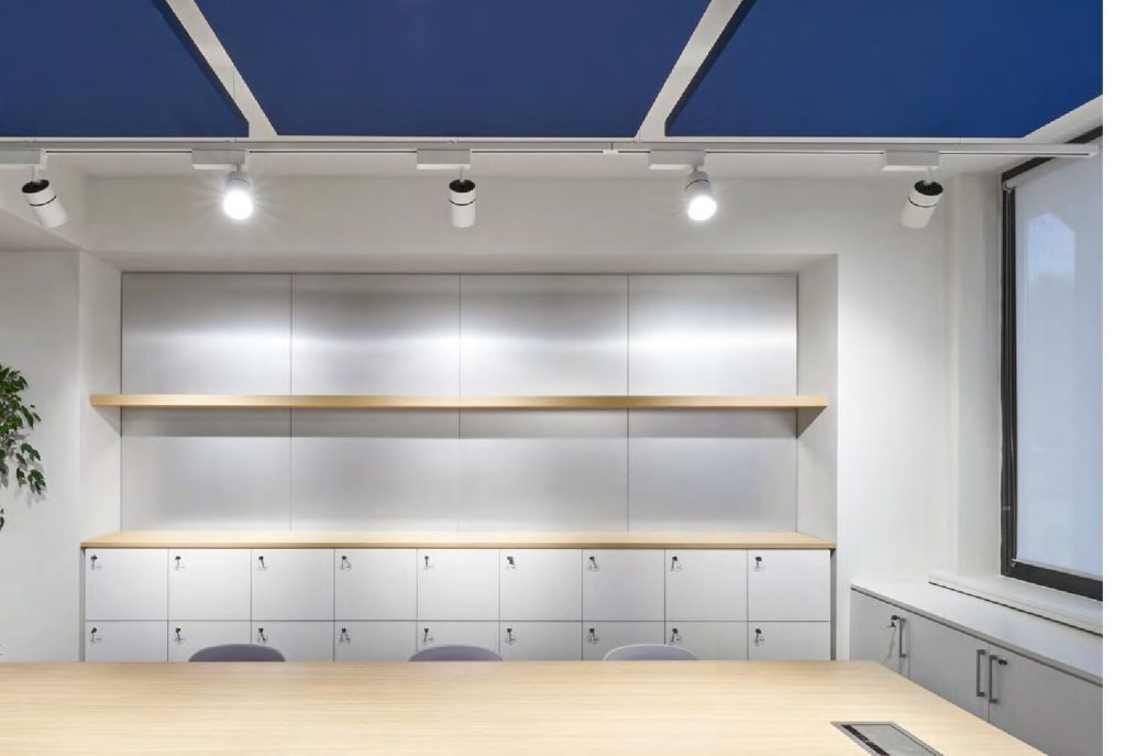 Pannello fonoassorbente Quartetto a soffitto blu in sala con arredi in legno — ufficio IPTV