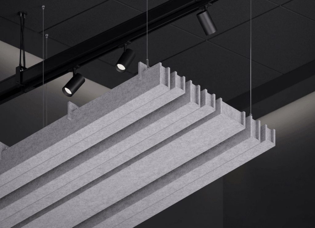 Modulo di baffle acustici EasySnap sospeso a cavi accanto a un binario di faretti